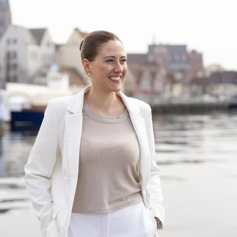 Coachin Leonie Annika Schlecht denkt an ihre Vision und blickt dabei in die Ferne, im Hintergrund ist das Wasser der Wismarer Bucht zu sehen